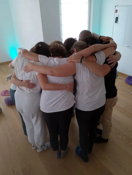 Un gruppo di persone riunite in un abbraccio